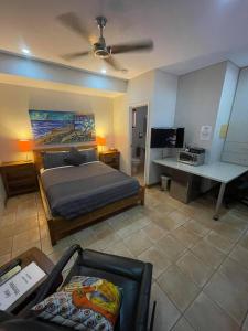a bedroom with a bed and a desk with a television at Samson Beach Chalets in Point Samson