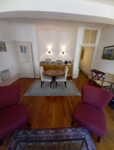 ein Wohnzimmer mit einem Tisch und 2 Stühlen in der Unterkunft Beaune City Suite in Beaune