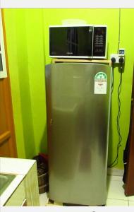 eine Mikrowelle auf einem Kühlschrank in der Küche in der Unterkunft Tazama place in Nyeri