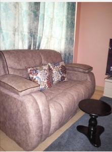 un sofá con almohadas en la sala de estar en Tazama place, en Nyeri