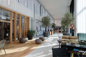 un hall avec des tables, des chaises et des plantes en pot dans l'établissement Triiiple Suites Level 21 mit Balkon und Tiefgarage, à Vienne