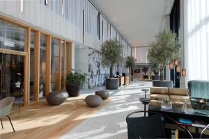 a lobby with tables and chairs and potted plants at Triiiple Suites Level 21 mit Balkon und Tiefgarage in Vienna