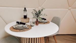 a table with two chairs and a white table with dishes on it at Romantische glamping dome Koksijde - Duiniek in Koksijde