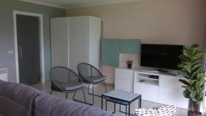 a living room with chairs and a flat screen tv at residentie Den Oever in Nieuwpoort