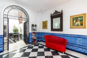 a red couch sitting in the middle of a room at Cool Sevilla Hotel in Seville