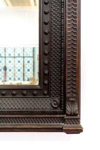 an ornate wooden mirror with a wooden frame on a wall at Cool Sevilla Hotel in Seville