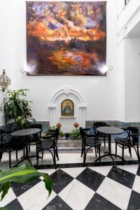 een schilderij aan de muur van een restaurant met tafels en stoelen bij Cool Sevilla Hotel in Sevilla