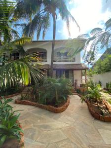 a house with palm trees in front of it at Siri Beach Lodge in Nungwi