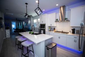 a kitchen with white cabinets and a white counter top at Newly Constructed Modern Pet Friendly Zen Home with Private Home Theater & Hot Tub! home in Orlando