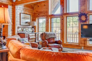 uma sala de estar com um sofá e cadeiras e uma televisão em Mount Snow Cabin em Wilmington