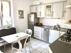 a kitchen with white cabinets and a white table and chairs at Apartament Familia in Ustrzyki Dolne