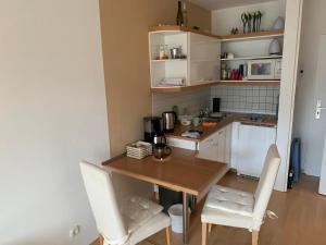 una pequeña cocina con mesa de madera y sillas en Appartement mit herrlicher Aussicht übers Murgtal en Baiersbronn