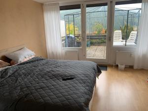 a bedroom with a bed and a balcony with chairs at Appartement mit herrlicher Aussicht übers Murgtal in Baiersbronn