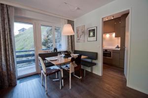 eine Küche und ein Esszimmer mit einem Tisch und einem Fenster in der Unterkunft Haus Bodmen C, Apartment Edelweiss in Zermatt