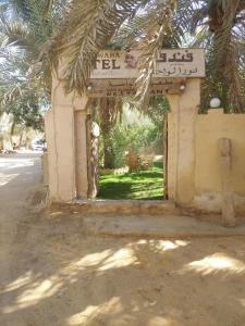 een ingang van een gebouw met een straatbord bij Nour El Waha Hotel in Siwa