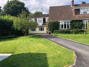 a house with a driveway in front of a yard at Lovely ground floor apartment in quiet village in Exeter