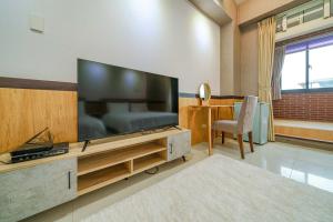 uma sala de estar com uma grande televisão de ecrã plano em 鼎愛溫泉行館 em Jiaoxi
