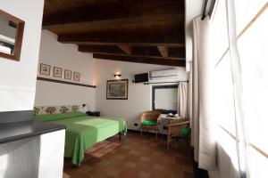 um quarto com uma cama verde e uma mesa em L' Amandola em Levanto