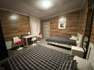 a bedroom with a bed and a desk and a table at Hostel Piaseczno in Piaseczno