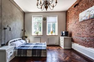 a bedroom with a bed and a brick wall at Green Garden !svitlo postiyno! in Lviv