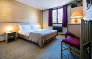 a hotel room with a bed and a window at Hôtel Le Savoie in Albertville