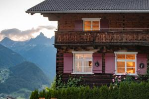 una casa con balcone e montagne sullo sfondo di Chalet "Altes Schulhaus" a Schruns