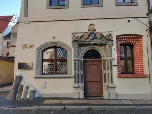 un edificio con una porta marrone e due finestre di Flyns a Görlitz