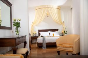 a bedroom with a bed and a chair and a desk at Halepa Hotel in Chania