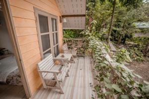 a porch with benches on the side of a house at Cozy Huts in Trat