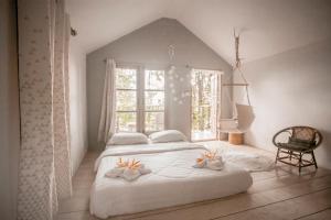 トラートにあるCozy Hutsの窓のある大きな白いベッドのある寝室