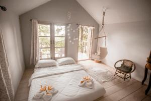 a bedroom with a large bed and a large window at Cozy Huts in Trat