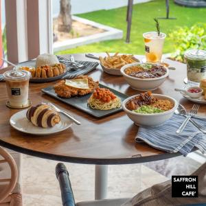 a table with plates of food and drinks on it at Saffron Hill Minburi in Min Buri