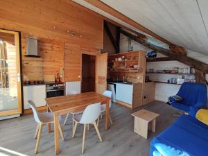 Puy-Sanières的住宿－La Rawette，厨房以及带木桌和椅子的用餐室。