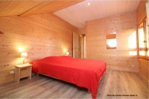 Puy-Sanières的住宿－La Rawette，木制客房内的一张红色床
