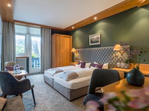 une chambre d'hôtel avec un lit et un canapé dans l'établissement Hotel Schwarzwaldhof, à Hinterzarten