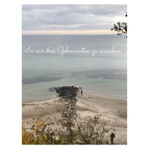 a person standing on a beach near the water at Kleines Landleben in Hohwacht