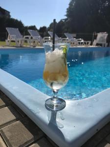 a drink sitting on a table next to a swimming pool at Hotel Rezydencja Mazury SPA & Lake in Mrągowo