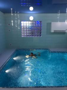 姆龍戈沃的住宿－Hotel Rezydencja Mazury SPA & Lake，男人在大型游泳池游泳