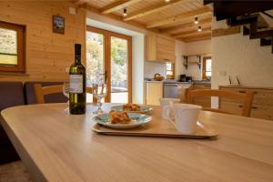 a table with a bottle of wine and a plate of food at Mountain Lodge Jereka in Bohinj