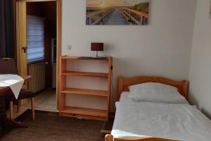 Dormitorio pequeño con cama y estante de libros en Pension Burger B&B, en Weibersbrunn
