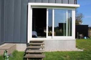a house with sliding glass doors on the side of it at BakBoord in Grou