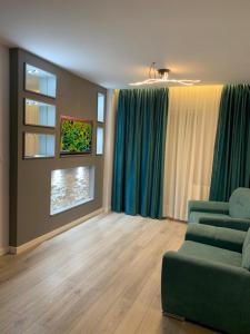 a living room with a green couch and a window at Doftana Apartaments in Teşila