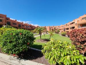 a park in front of a large apartment building at Casa Soleada close to the sea + beach, Wifi, 2 pools, terrace, sea view, SAT-TV in Granadilla de Abona