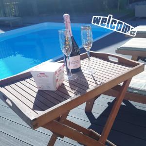 two wine glasses and a box on a table next to a pool at Отель Villa History in Zelenogradsk