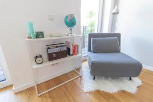 a chair in a living room with a book shelf at Boutique Sky City Apt. with BALCONY / TOP SPOT in Vienna