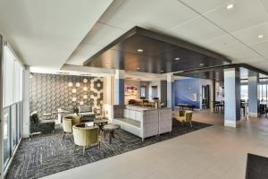 een lobby met een bank, stoelen en tafels bij Holiday Inn Express & Suites - Nashville MetroCenter Downtown, an IHG Hotel in Nashville