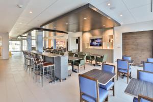 a restaurant with tables and chairs and a bar at Holiday Inn Express & Suites - Nashville MetroCenter Downtown by IHG in Nashville