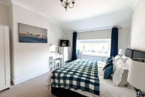 a bedroom with a bed with a checkered blanket at NORTH BEACH HOUSE - 3 Bedroom Fully Equipped Spacious House Perfect for Family Getaways in Bridlington in Bridlington