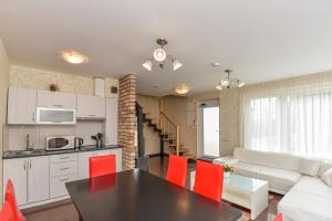 a kitchen and living room with a table and red chairs at Guest House Pasaulio Krastas in Palanga +54 photos