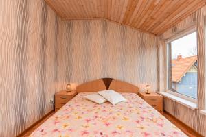 a bedroom with a bed with two pillows and a window at Guest House Pasaulio Krastas in Palanga